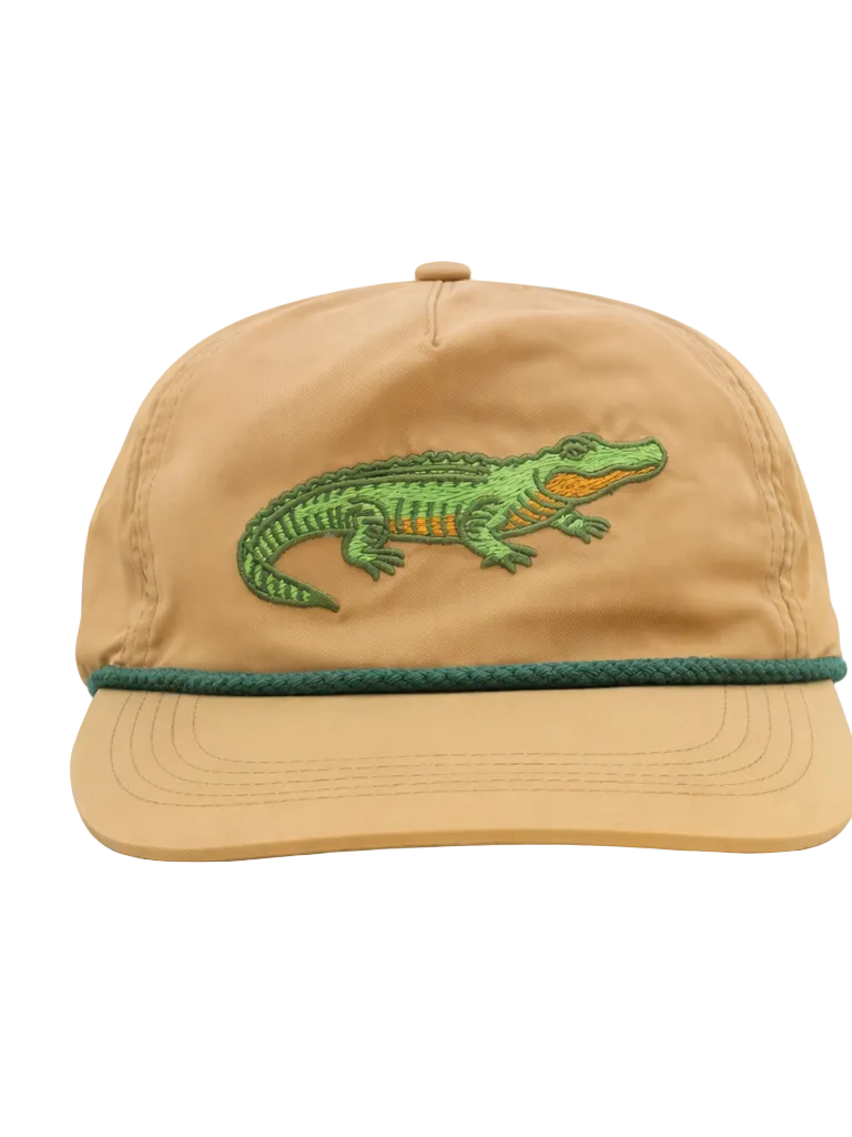 Tan cap with green alligator embroidery on a white background